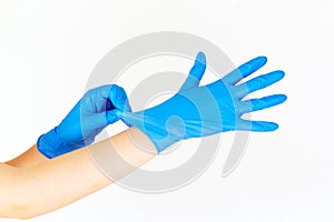 Stock photo of a woman`s hands putting on blue latex gloves isolated on white