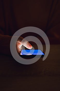 Stock photo of a woman using smartphone in the dark