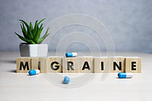 Stock photo The word Migraine along with paracetamol tablets