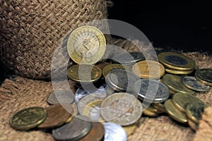 Stock pile of 1, 2, 5, 10 Indian rupee metal coin currency isolated on sack background. Financial, economy, Banking and exchange