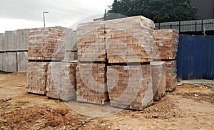 Stock pile of clay brick on wooden pallets stacked at the construction site.
