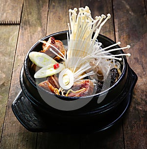 Stock pot on a stove with vegetables enokitake and beef