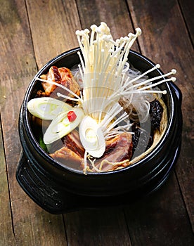 Stock pot on a stove with vegetables enokitake and beef