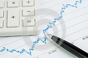 Stock price drop and growth chart with calculator and pen using as financial analysis, stock market price volatility report or