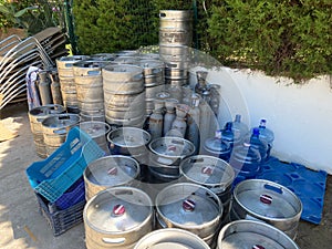 Stock of steel beer kegs on the wooden palettes. Many beer barrels at a beer factory