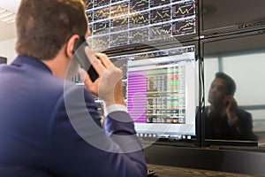 Stock trader looking at computer screens.