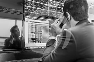 Stock trader looking at market data on computer screens.