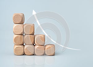 Stock trading. Finance. Investing. Growing business. Wooden blocks arranged with arrows pointing upwards and a white background