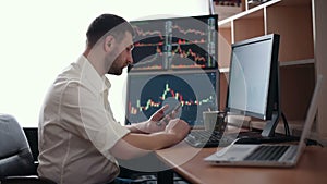 Stockbroker in white shirt is working in a monitoring room with display screens. Stock Exchange Trading Forex Finance