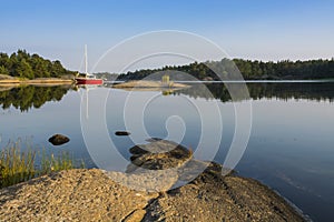 Stockholm archipelago: moored red sailingboat in natural harbour photo