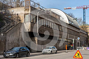 street view of old concrete subway station building entrance with incidental people in Stockholm.