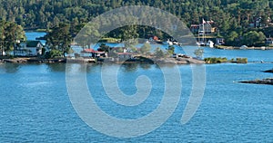 Stockholm, Sweden. Beautiful Red Swedish Wooden Sauna Logs Cabins Houses On Island Coast In Summer Sunny Evening Near