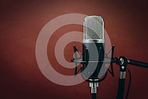 StockImage Studio podcast microphone on dark brown background, broadcasting equipment photo