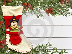 Stocking Befana and Christmas decorations on wooden white background photo