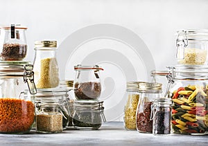 Stocks or set of cereals, pasta, groats, organic legumes and useful seeds in glass jars. Vegan source of protein and energy