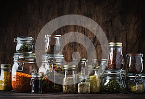 Stocks or set of cereals, pasta, groats, organic legumes and useful seeds in glass jars. Vegan source of protein and energy