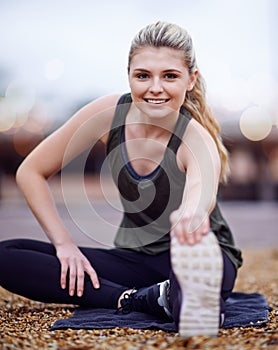 Stoked for this run. a young woman stretching her legs before a run. photo