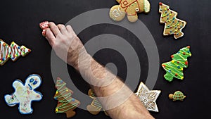 Stoker photographer laying out festive gingerbread on dark background