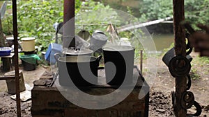 A stoker placing a pot over heat.