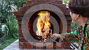 Stoking Fire In A Garden Fireplace