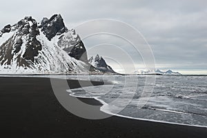 Stokksnes Peninsula, Vestrahorn mountains and black sand ocean coast line, Iceland photo