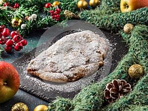 Stollen. Traditional German Christmas cupcake with nuts and dried fruits. Sweet New Year holiday cake on dark background