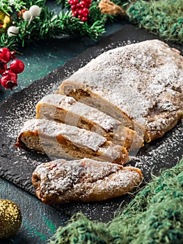 Stollen. Traditional German Christmas cupcake with nuts and dried fruits. Sweet New Year holiday cake on dark background