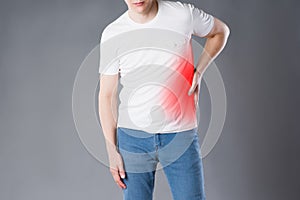 Stomach ache, man suffering with abdominal pain on gray background