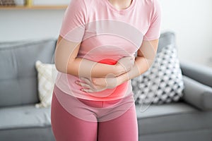 Stomach ache, symptoms of gastritis or pancreatitis, woman with abdominal pain at home interior