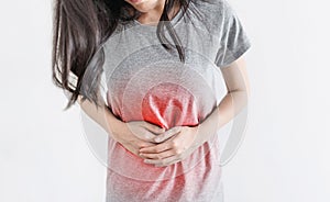 Stomach aches and Monthly period pain. Young woman holding stomach with red highlight photo