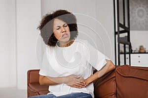 Stomach pain. Sick african american girl hold abdomen because it hurts. Pancreatitis disease of pancreas becomes