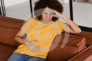 Stomach pain. Sick african american girl hold abdomen because it hurts. Pancreatitis disease of pancreas becomes