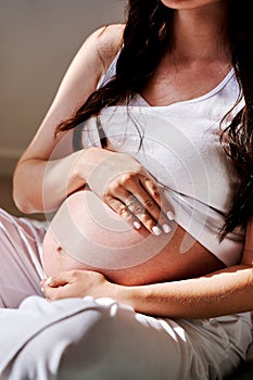 the stomach of a pregnant woman in close-up with an ultrasound image.