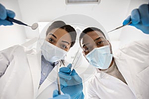 Stomatological Treatment. Black dentist and doctors assistant checking patients teeth, low angle