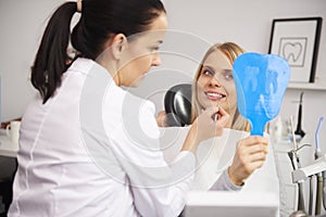 Stomatologist checking the woman`s teeth during dental checkup