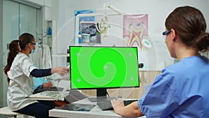 Stomatologist nurse looking at green screen tablet