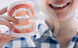 Stomatology concept, partial portrait of girl with strong white teeth looking at camera and smiling, fingers near face. Closeup of