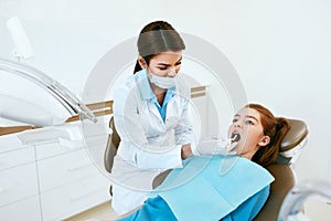 Stomatology. Dentist Working With Girl Teeth In Dental Clinic.