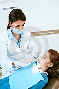 Stomatology. Dentist Working With Girl Teeth In Dental Clinic.