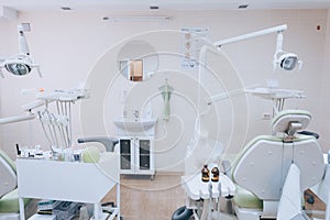 Stomatology interior of small dental clinic with professional chair in green colors. Dentistry, medicine, medical equipment and