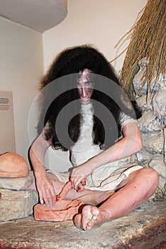 Stone age statue of a man sitting making a terracotta pot, Ronda, Spain.