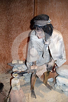 Stone age statue of a man working with molten metal in the Mondragon Palace museum, Ronda, Spain.