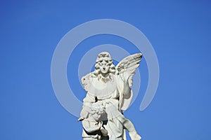 Stone angel and child figurine on historic cemetery