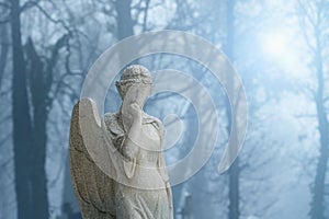 Stone angel on a light, foggy background