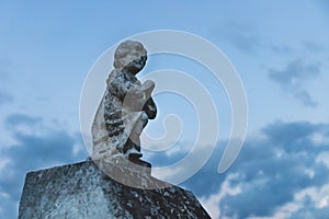 Stone angel statue praying at the cemetery `Cementerio General` in Merida, Yucatan, Mexico