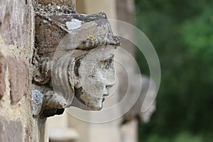 Stone angel woman gargoyle sculpture at church entrance
