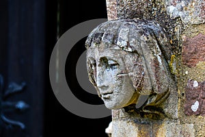 Stone angel woman gargoyle sculpture at church entrance