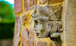 Stone angel woman gargoyle sculpture at church entrance