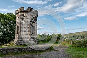 Stone Apothecarys Tower at The Lump and Fancy Hill in Portree, Scotland with a blue sky