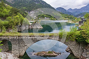 Stone arch bridge and mountain lake